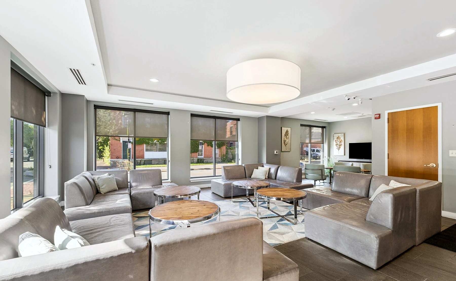 The community room at 50 Charlotte Square, with lounge seating along a wall of windows